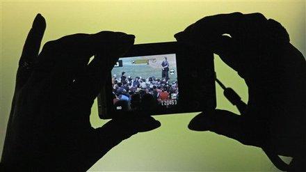 A fan takes pictures of the San Francisco Giants celebrating after Game 5 of baseball's World Series against the Texas Rangers Monday, Nov. 1, 2010, in Arlington, Texas. The Giants won 3-1 to capture the World Series.